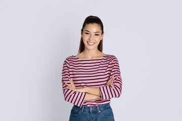 Studio shot of cheerful attractive young brunette woman in casual