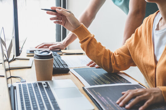 Programmers cooperating at Developing programming and website working in a software develop company office, writing codes and typing data code, Programming with HTML, PHP and javascript