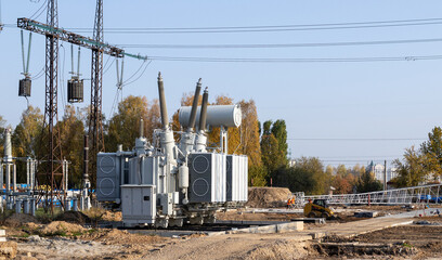 The outdoor extra high voltage power transformer. A high-voltage power electrical substation. Assembly work of power units at the substation. - 621650229