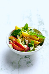 Summer nectarine salad with green leaf vegetables and feta