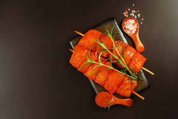 Close up of chicken meat.Procurement for designers.Food concept.Chicken breast Fillets.Fresh raw marinated chicken fillet skewers with fresh herbs on a black background.Top view.