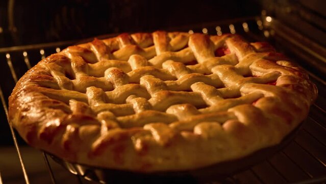 Tasty pie in oven. Timelapse of homemade pie baked. Baking concept. Delicious Apple Cherry Pie rising up in oven. Process of baking berry pie with apples and cherry baked in oven. 4K, UHD