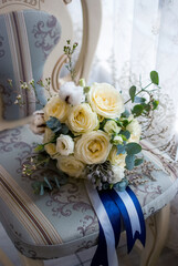 festive bouquet wedding engagement of white roses with ribbon on antique chair