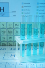 Test tubes against periodic table of elements, closeup. Color tone effect