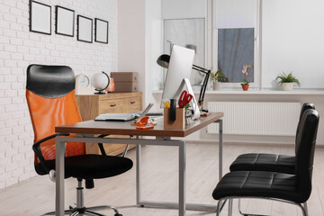 Stylish director's workplace with comfortable furniture, computer and accessories in office. Interior design