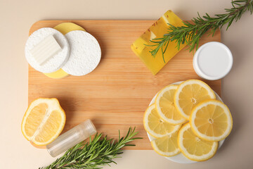 Lemon face cleanser. Fresh citrus fruits, rosemary and personal care products on beige background, flat lay