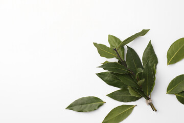 Aromatic fresh bay leaves on white background, flat lay. Space for text