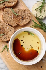 Bowl of organic balsamic vinegar with oil, bread slices and spices on white table, flat lay