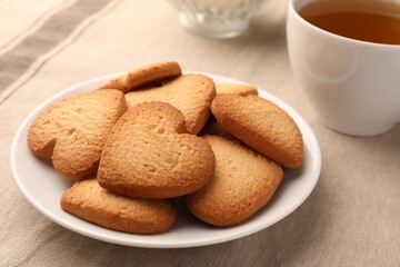 Fototapeta na wymiar Heart shaped Danish butter cookies and tea on table, closeup