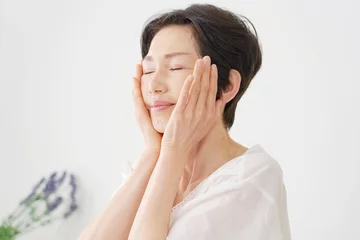 Foto auf Acrylglas Massagesalon 自宅で顔のスキンケアをする中年の女性