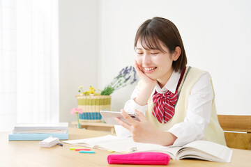 勉強中にスマホを見て息抜きする女子高生