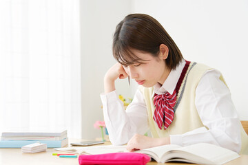 自宅で勉強中に居眠りする女子高生