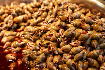 River snails in a bowl. Chinese Delicacy of Small Seafood Dunked in Flavorful Sauce.