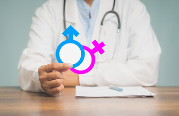 A physician holds gender emblems for men and women while sitting in the hospital