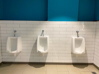 row of modern Urinals or urinoir on tiled wall, clean toilets concepts