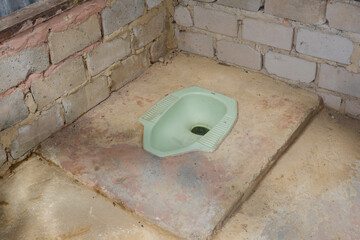 a simple squat toilet that is often used by Asians, especially in Indonesia. the concept of a squat...