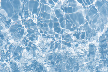 Blue water with ripples on the surface. Defocus blurred transparent blue colored clear calm water surface texture with splashes and bubbles. Water waves with shining pattern texture background.