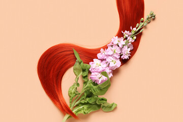 Ginger hair strand and beautiful flower on color background, closeup