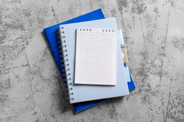 Stack of different notebooks on grunge background