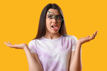 Crazy young woman wearing glasses on yellow background