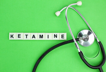 stethoscope and alphabet letters with the word ketamine. concept of medicine and disease