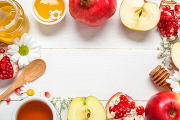 Frame made of fruits, flowers and honey on white wooden background, closeup. Rosh hashanah (Jewish New Year) celebration