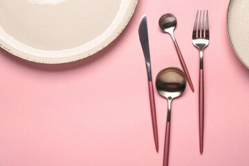 Clean plate and set of cutlery on pink background, closeup