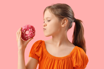 Thoughtful little girl with tasty doughnut on pink background, closeup