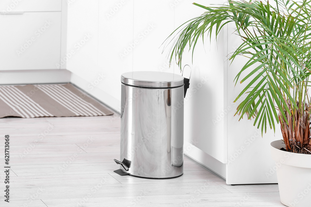 Sticker metallic trash bin in interior of light kitchen