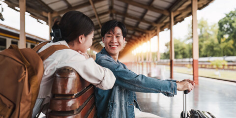 Asian couple at railway station have happy moment. Tourism and travel in the summer