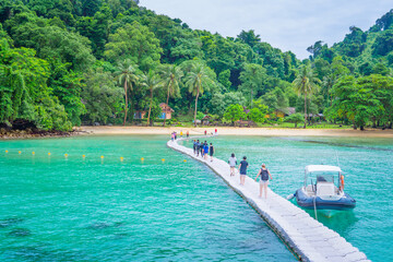 Male and female tourists walking on the pontoon 