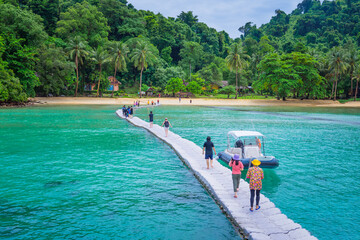 Male and female tourists walking on the pontoon 