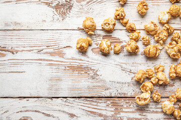 Tasty popcorn on white wooden background