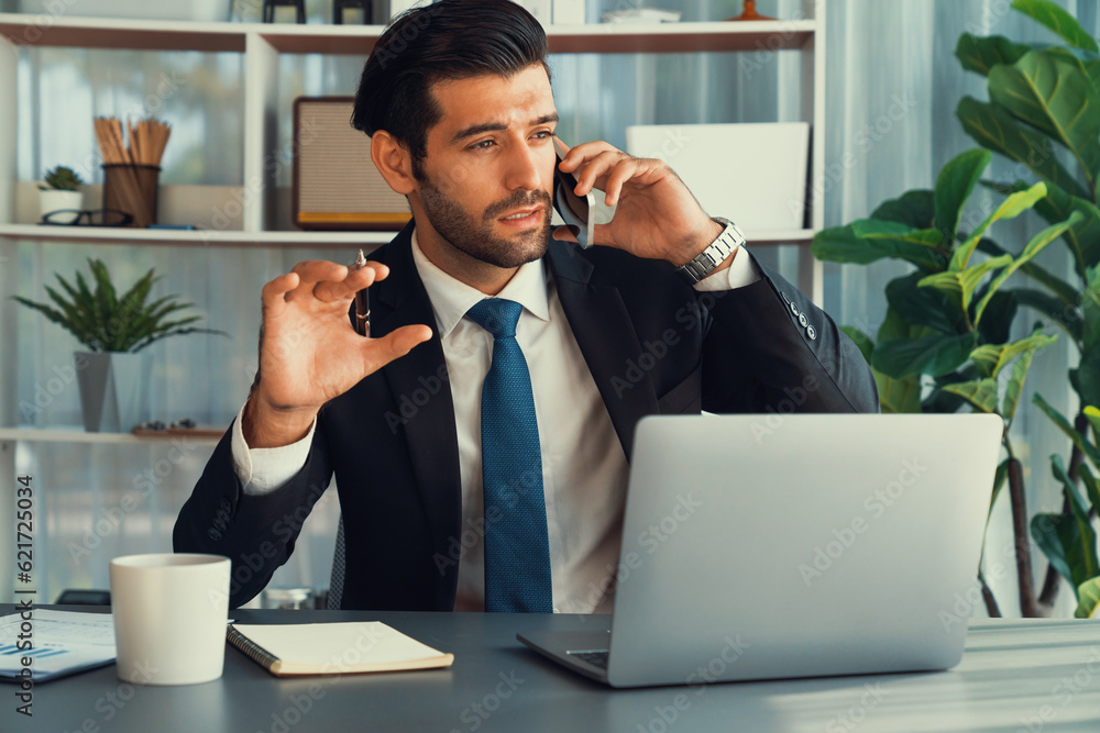 Poster diligent businessman busy talking on the phone call with clients while working with laptop in his of