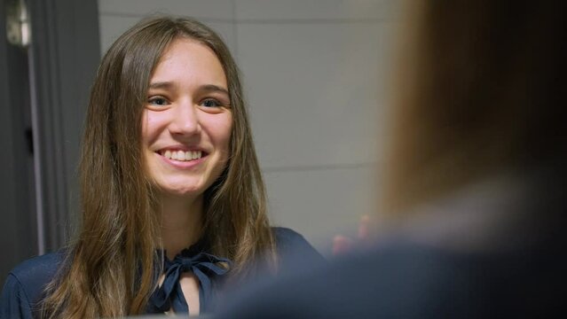 Close-up Caucasian woman smiling, giving herself high-five in mirror