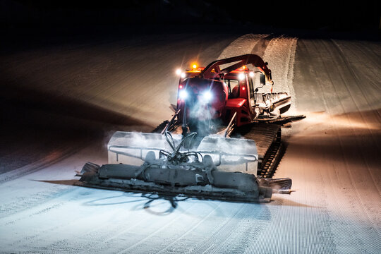 Snowcat ratrack machine making night snow at ski resort