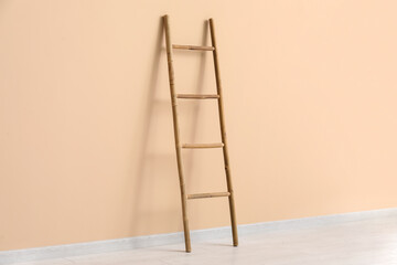 Wooden ladder near beige wall in room