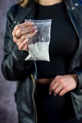 Packet with cocaine narcotic powder in female dealer, crime concept