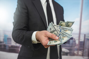 Hands of businessman holding us dollar bills close up, investment