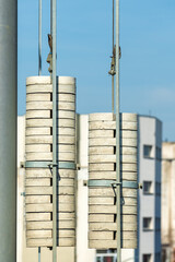 Electric train railway line tension pole with wires and concrete weights