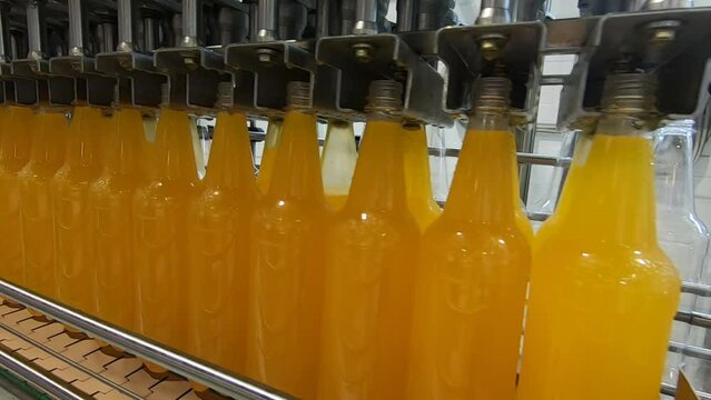 Bottling lemonade at the factory. Production of beverages - carbonated lemonade, carbonated water in plastic bottles - on an automatic conveyor.