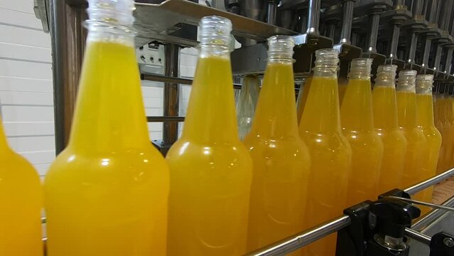 Bottling lemonade at the factory. Production of beverages - carbonated lemonade, carbonated water in plastic bottles - on an automatic conveyor.