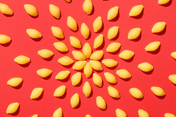 Uncooked pasta on red background