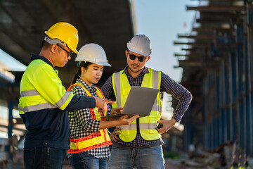 A Professional team of engineers, architects, civil engineers using tablet computers on construction site expressway construction project to discuss the details of the joint plan.