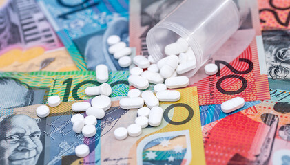 Dispersed white tablets on australian dollar banknotes