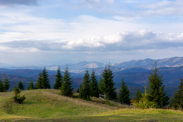 Fabulous landscape of autumn Carpathian Mountains in blue haze and sky with beautiful clouds. Wildlife. Environmental protection. Selective focus, defocus