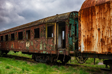 Old rusty passenger car abandoned on railway tracks