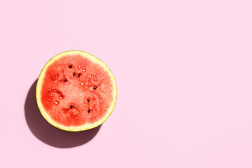 Half of fresh watermelon on pink background