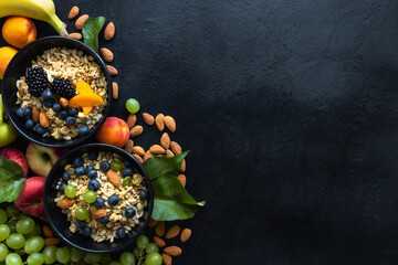 Two healthy breakfast bowl with ingredients granola fruits greek yogurt and berries on dark background with copy space top view. Weight loss, healthy lifestyle and eating concept