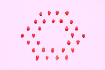 Frame made of fresh raspberries on pink background